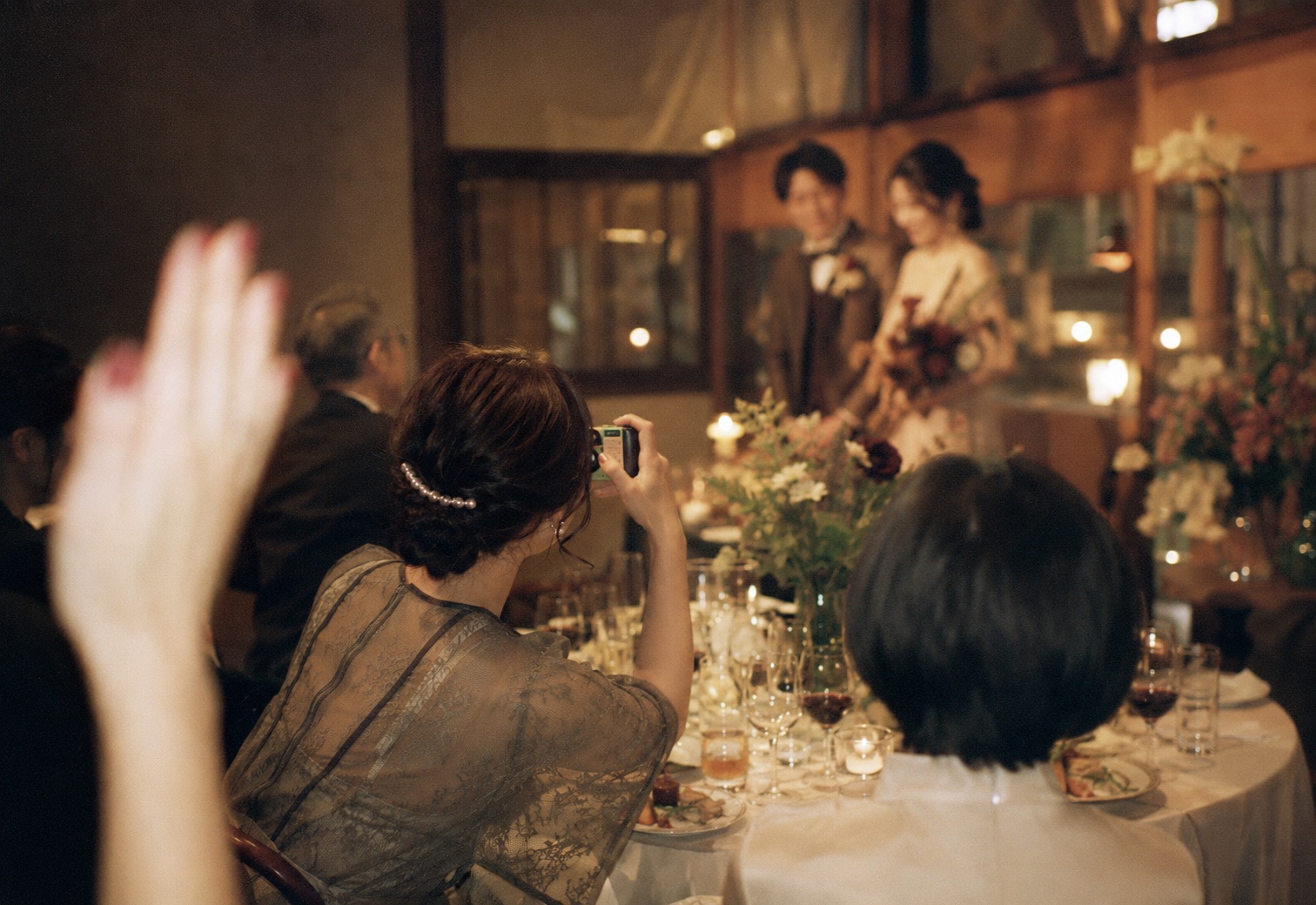 結婚式の披露宴で、ゲストがポイカメラで撮影している様子
